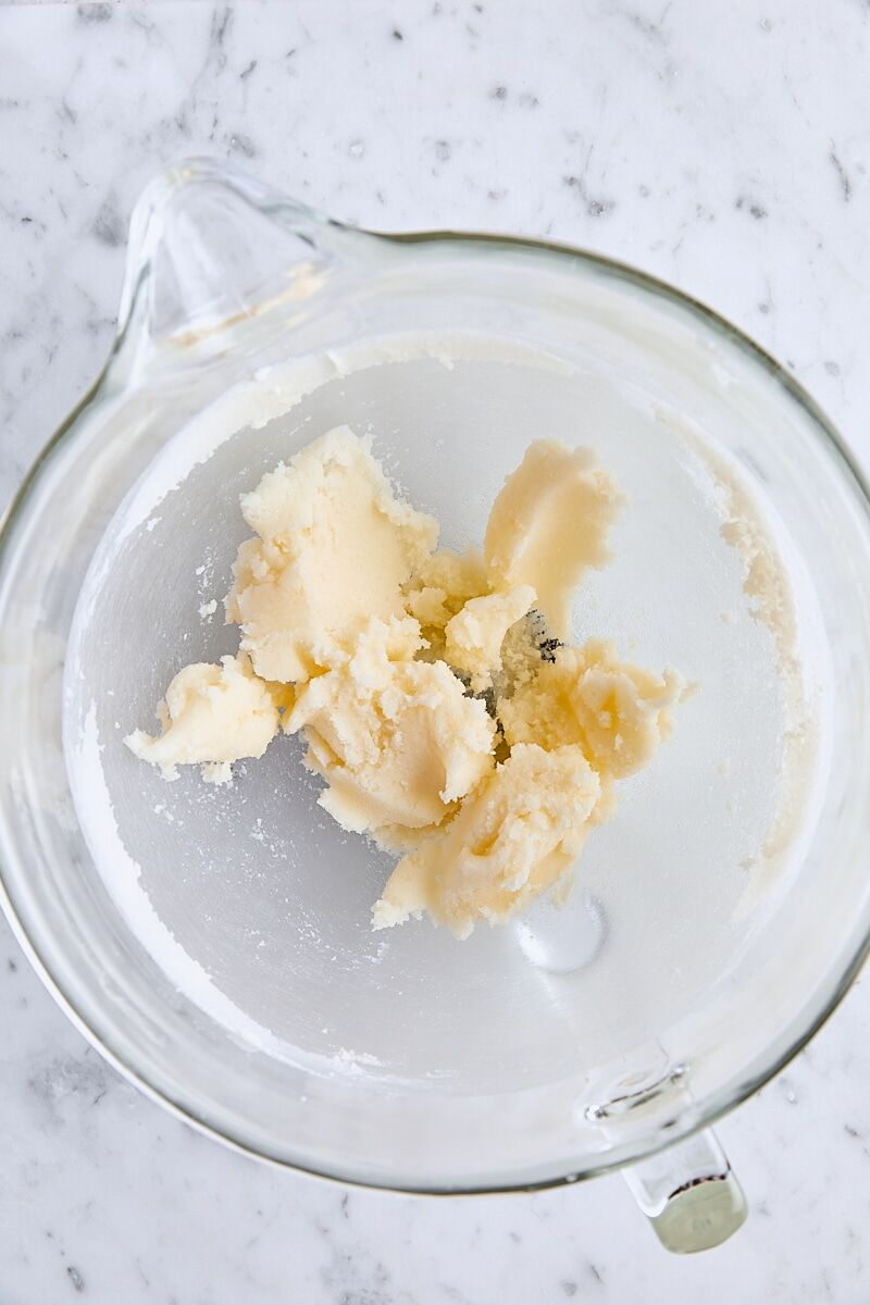 Butter and granulated sugar mixed together in glass mixing bowl