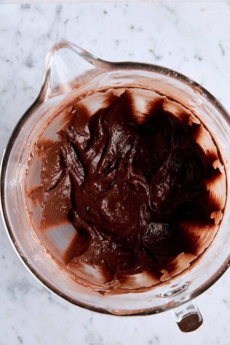 Espresso and boiling water mixed with batter in glass mixing bowl