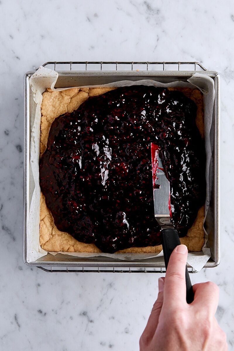 Blackberry filling spread over par-baked crust with an offset spatula