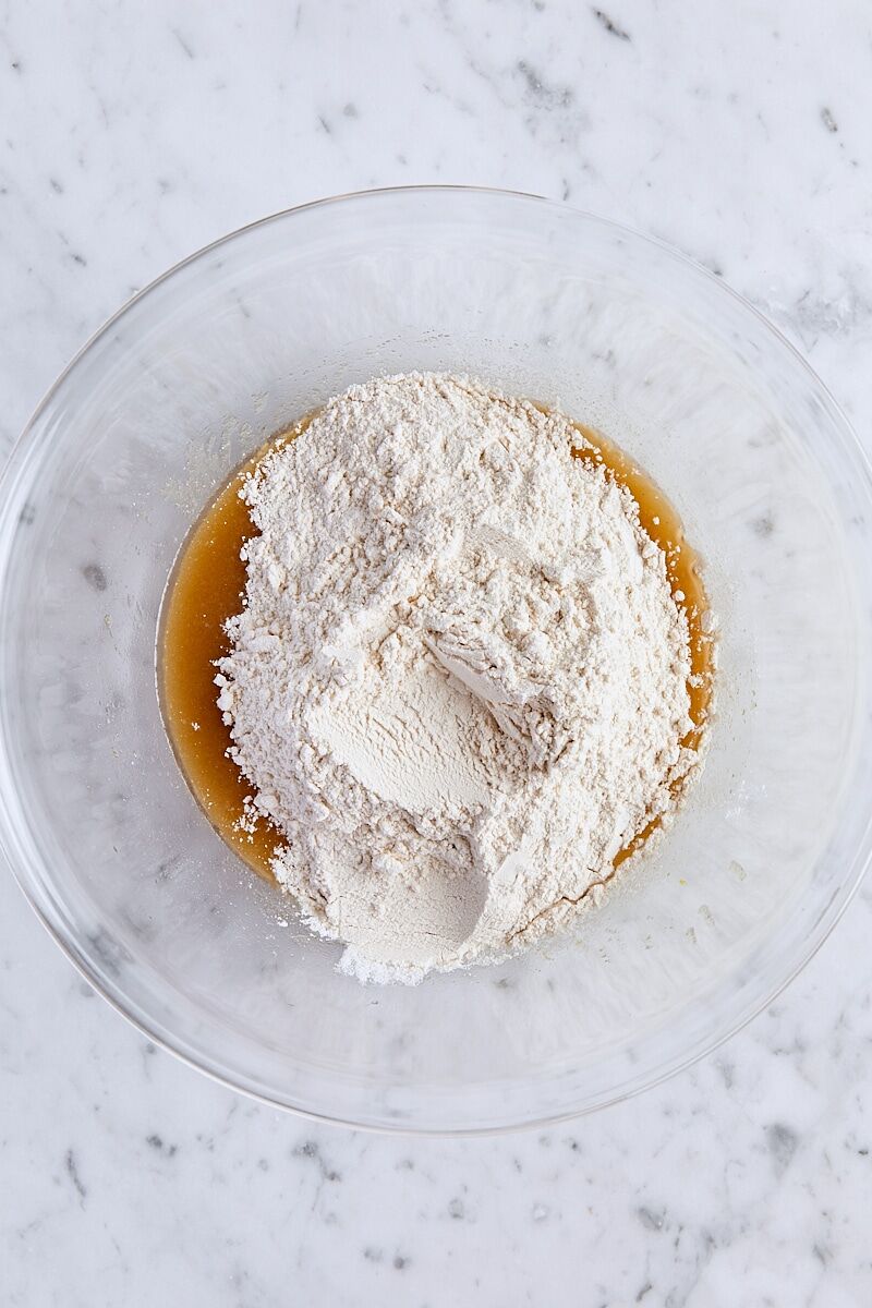 Dry ingredients added to melted butter mixture in large glass bowl