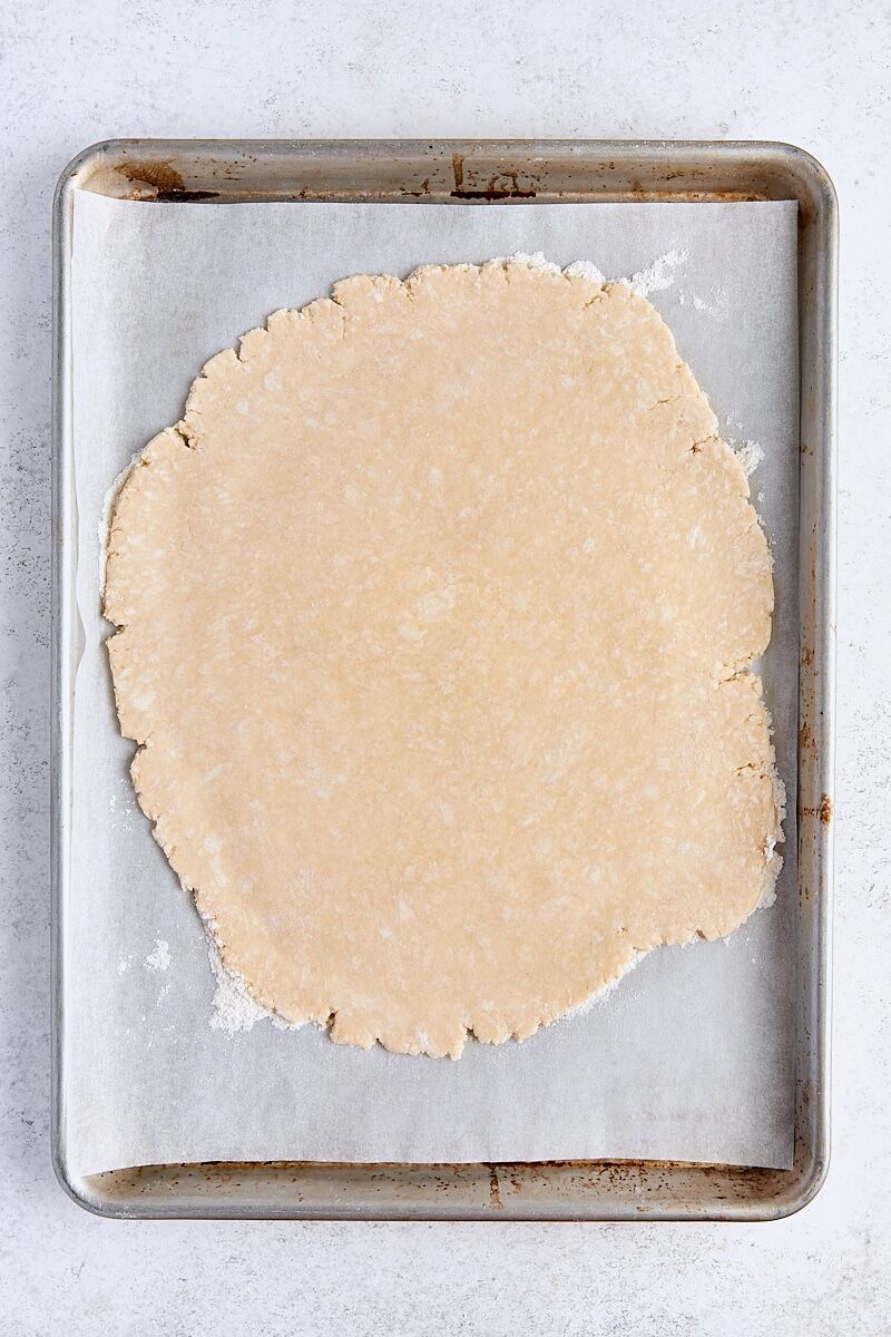 Galette dough rolled out on parchment-lined baking sheet