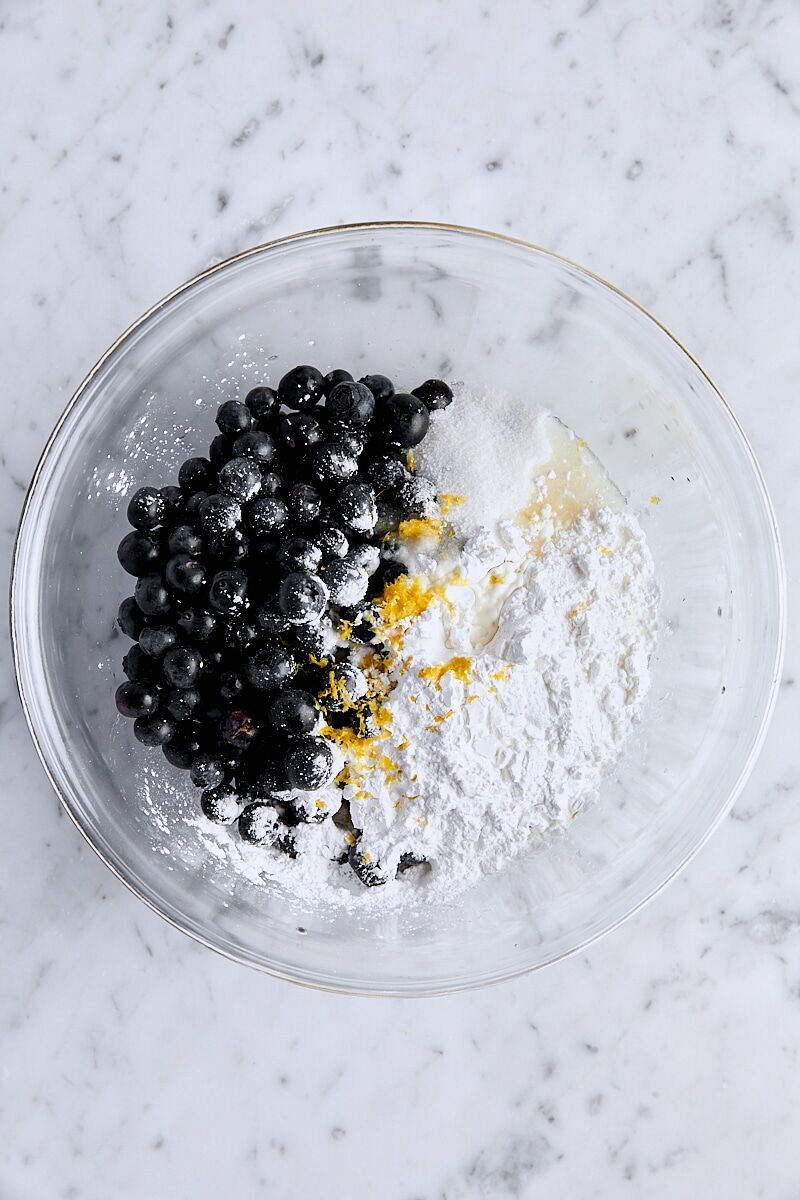 Crushed blueberries, whole blueberries, sugar, cornstarch, salt, lemon zest, and lemon juice in glass bowl