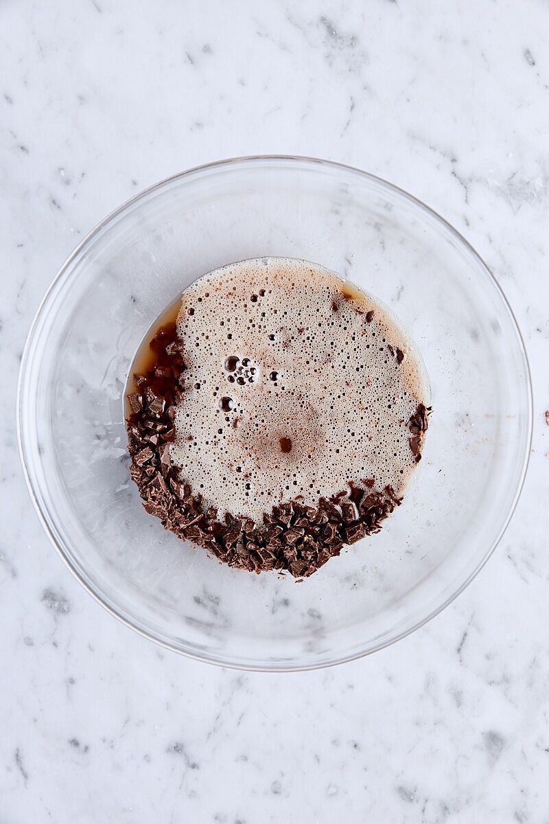 Brown butter poured over chopped semisweet chocolate in glass bowl