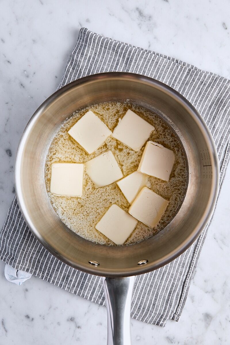 Sliced butter heated and starting to melt in saucepan