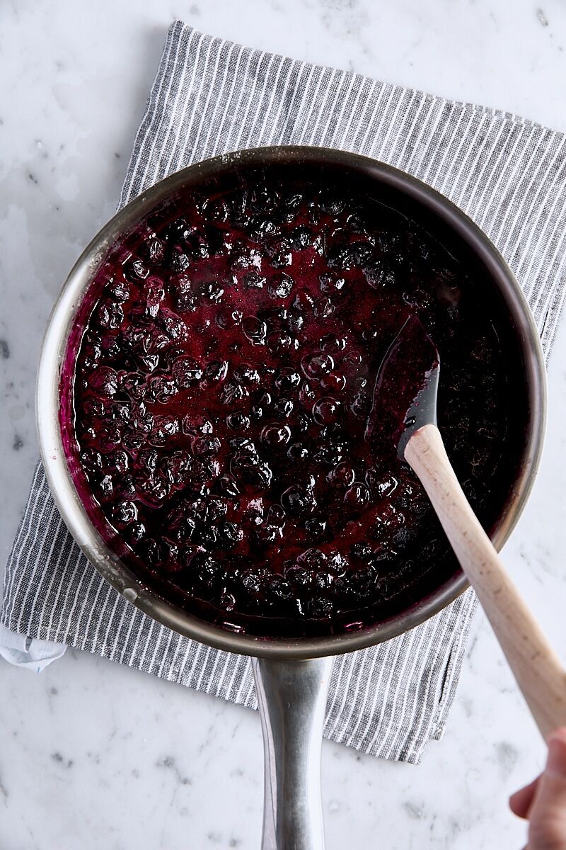 Blueberries cooked until reduced and softened in saucepan