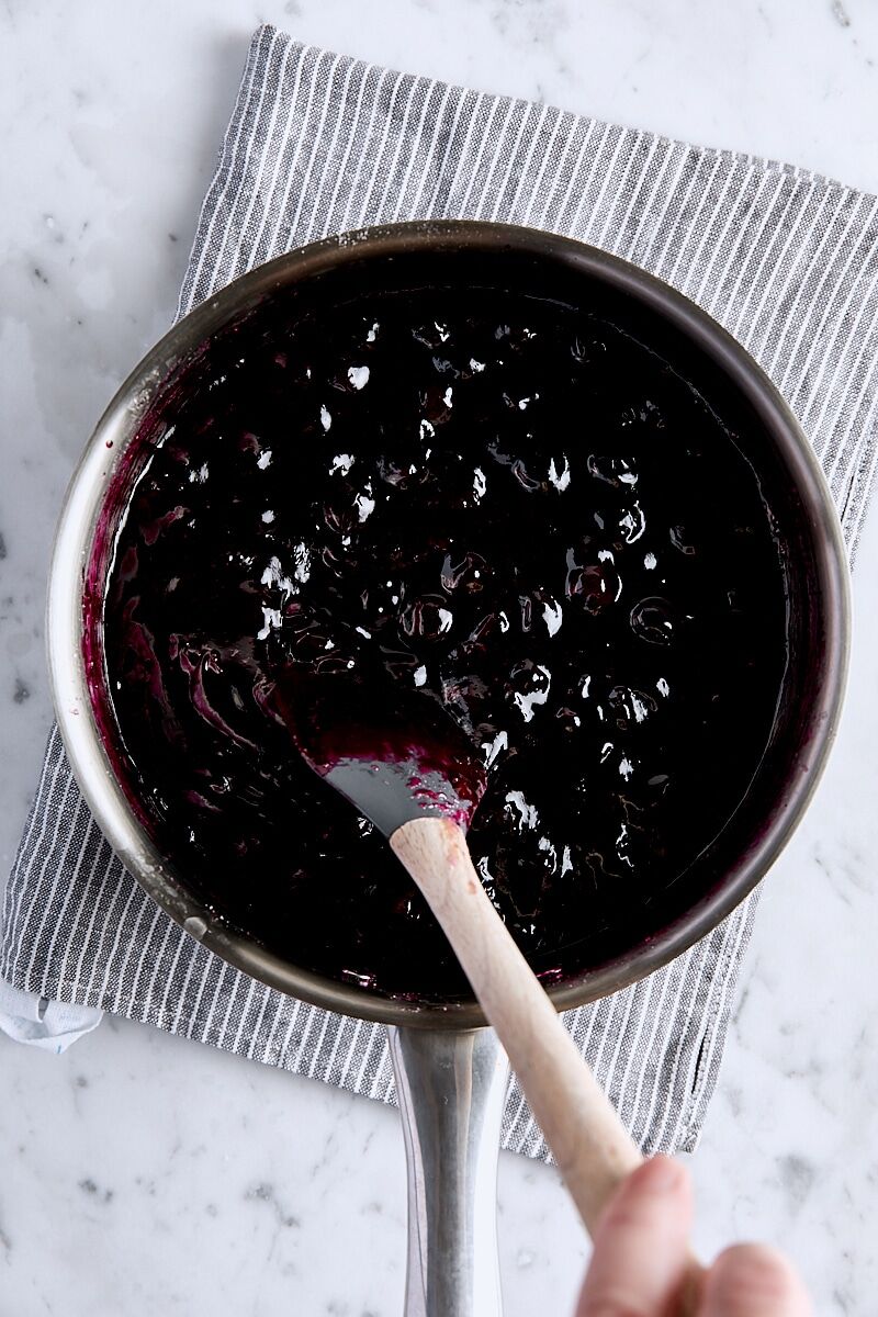 Cooked blueberry pie filling in saucepan with spatula
