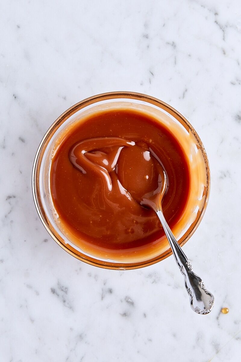 Salted caramel sauce in glass bowl with spoon