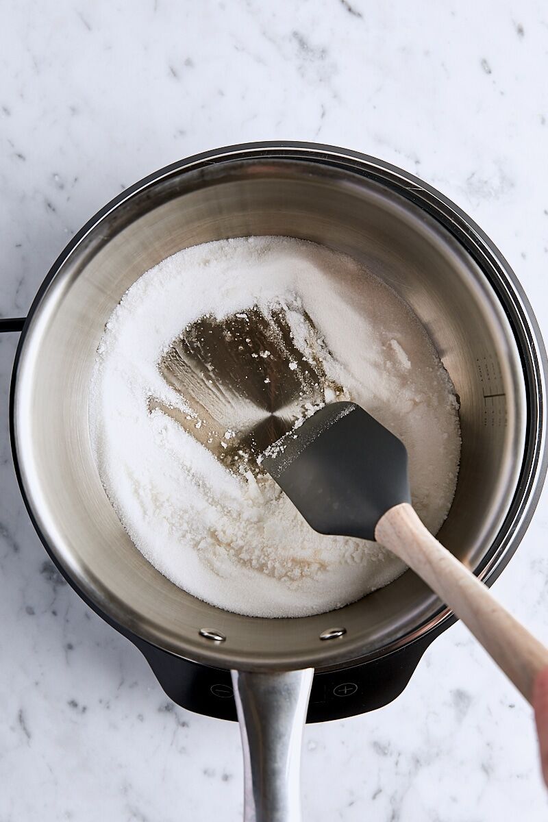 Granulated sugar heated in light-colored saucepan and beginning to melt