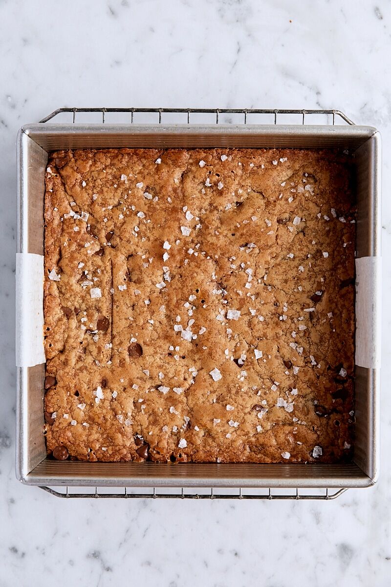 Baked chocolate toffee blondies in parchment-lined square pan
