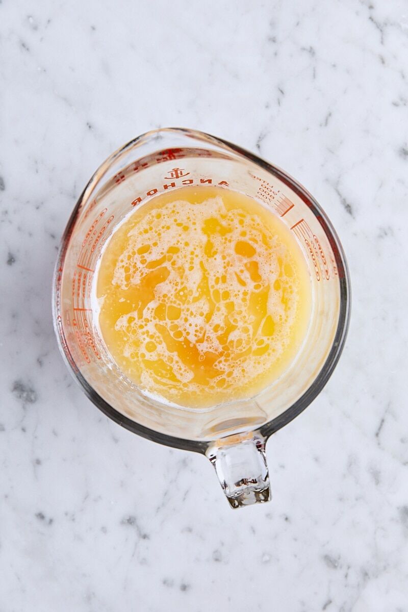 Milk, vanilla, melted butter, and eggs in glass measuring cup