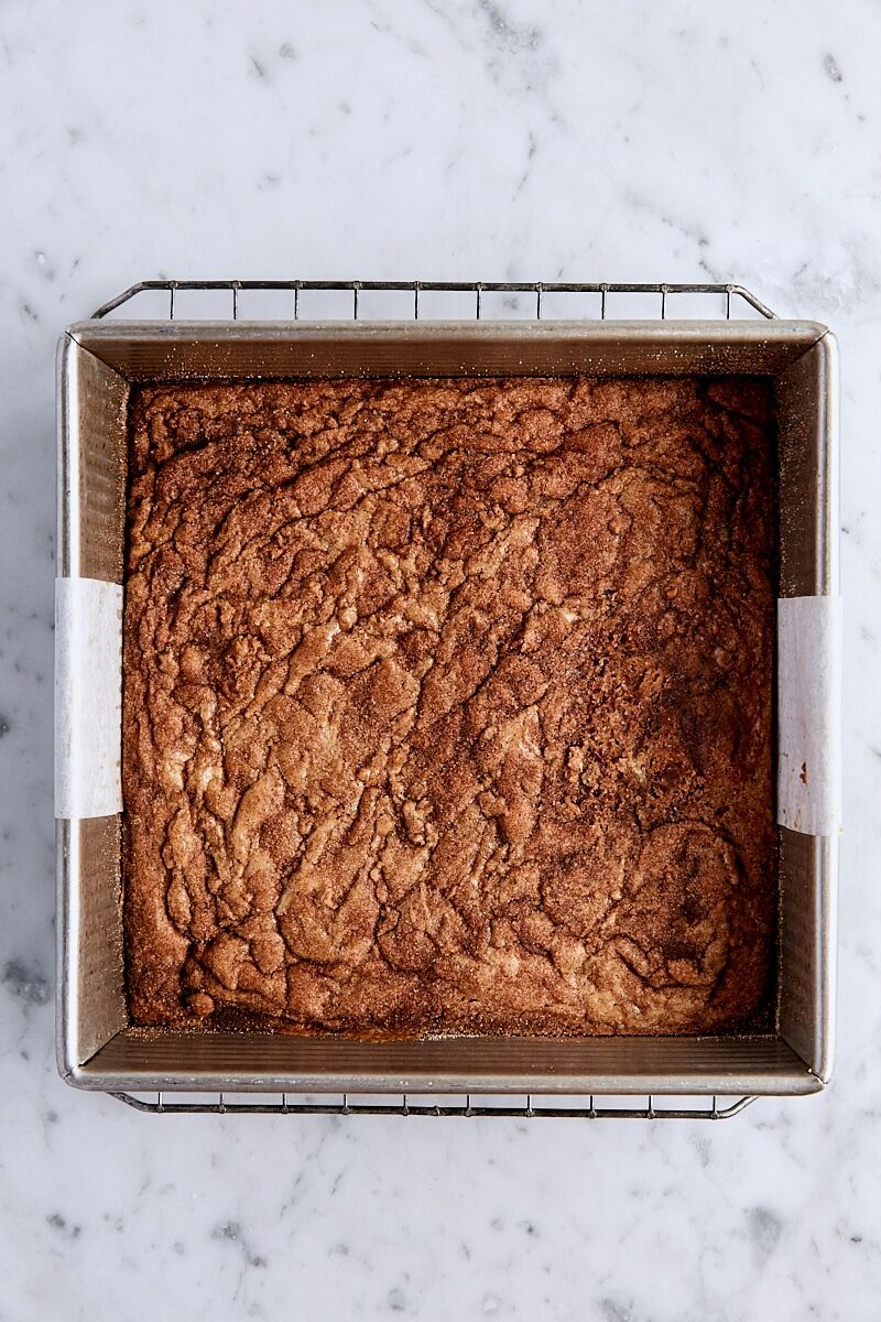 Baked snickerdoodle blondies in parchment-lined square pan