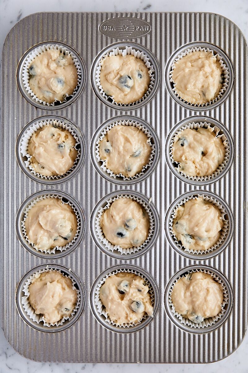Blueberry muffin batter scooped into muffin tin
