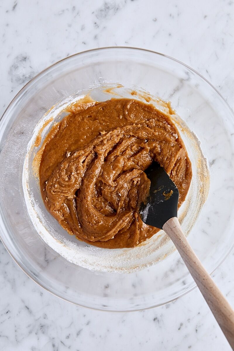 Peanut butter blondie batter folded with spatula in glass bowl