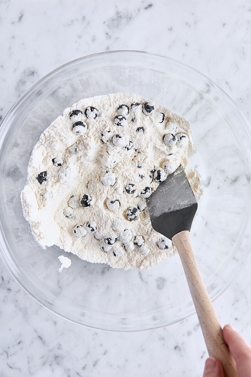 Blueberries tossed in dry ingredients in a large bowl