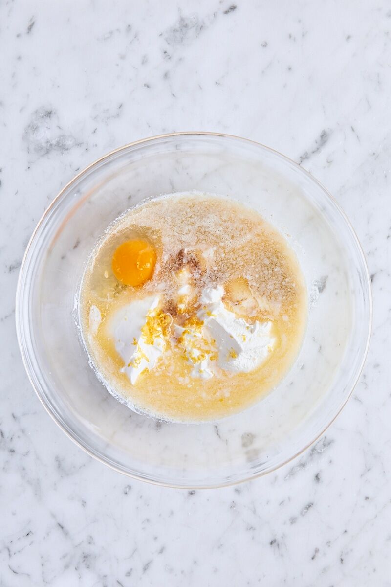 Milk, sour cream, melted butter, egg, lemon zest, and vanilla in glass bowl