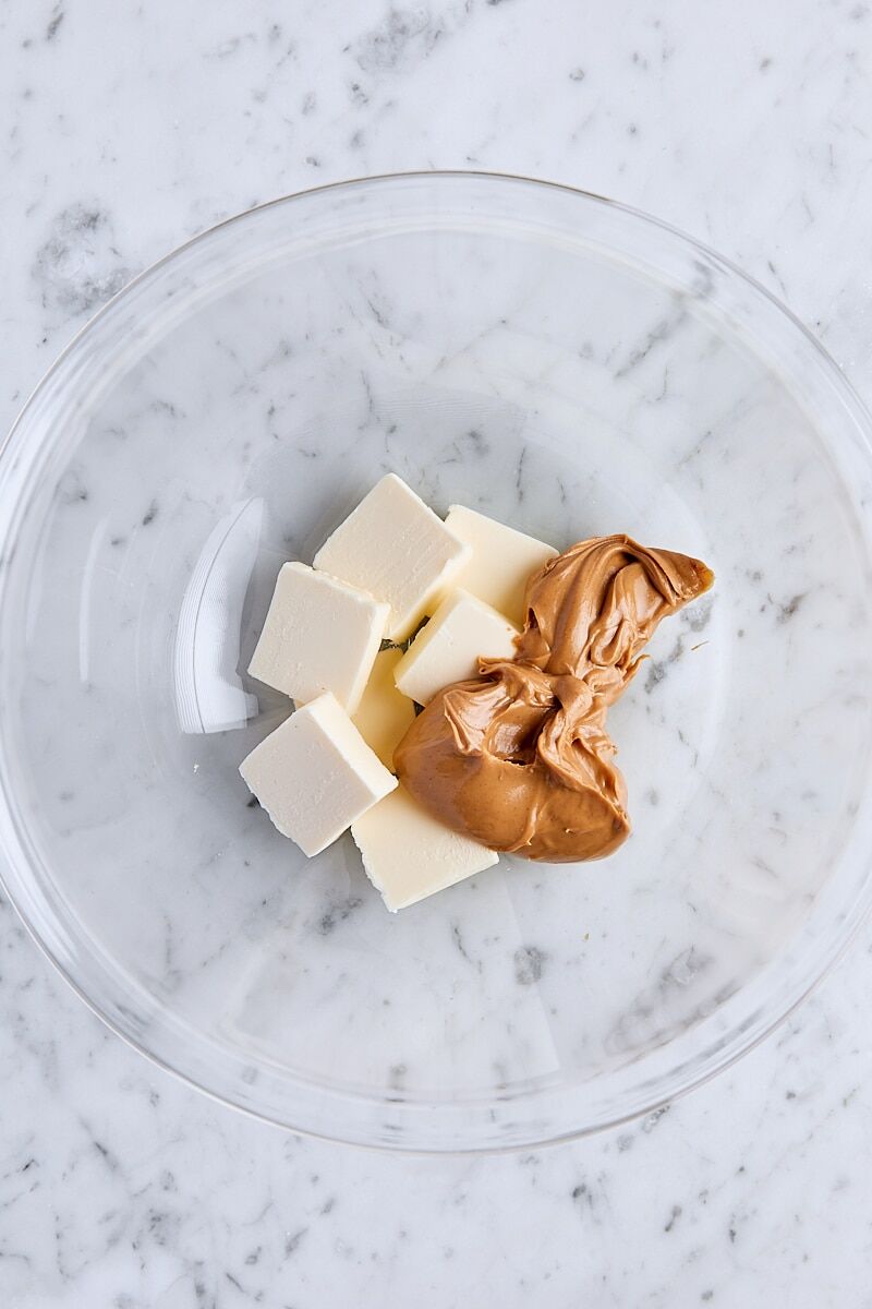 Sliced unsalted butter and creamy peanut butter in glass bowl