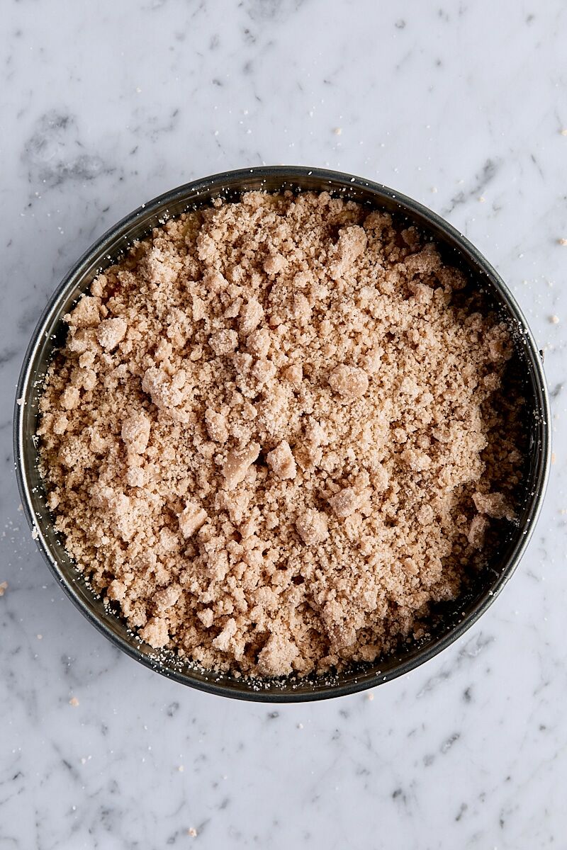 Crumb topping sprinkled over fresh peach layer