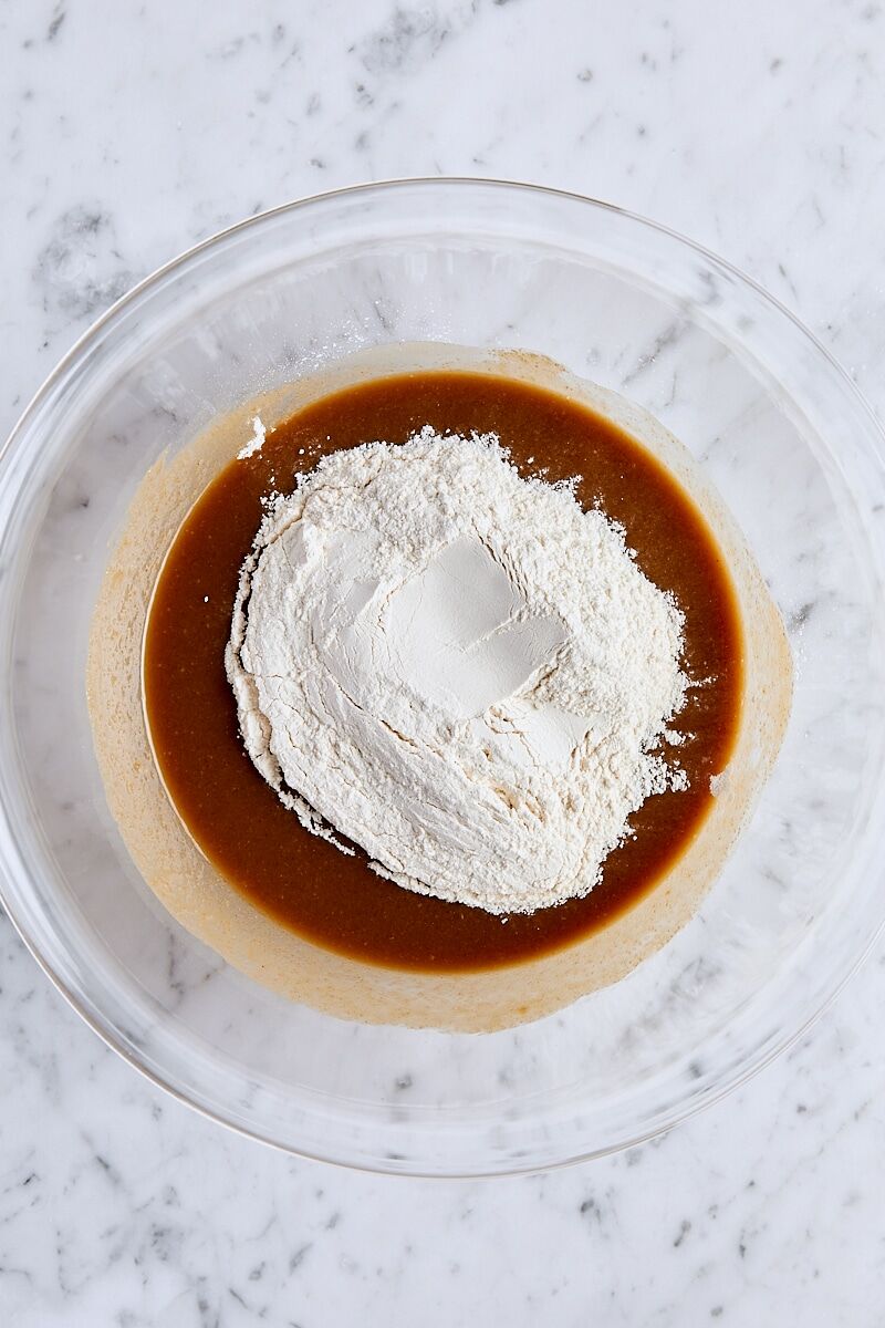 Flour added to peanut butter blondie batter in glass bowl