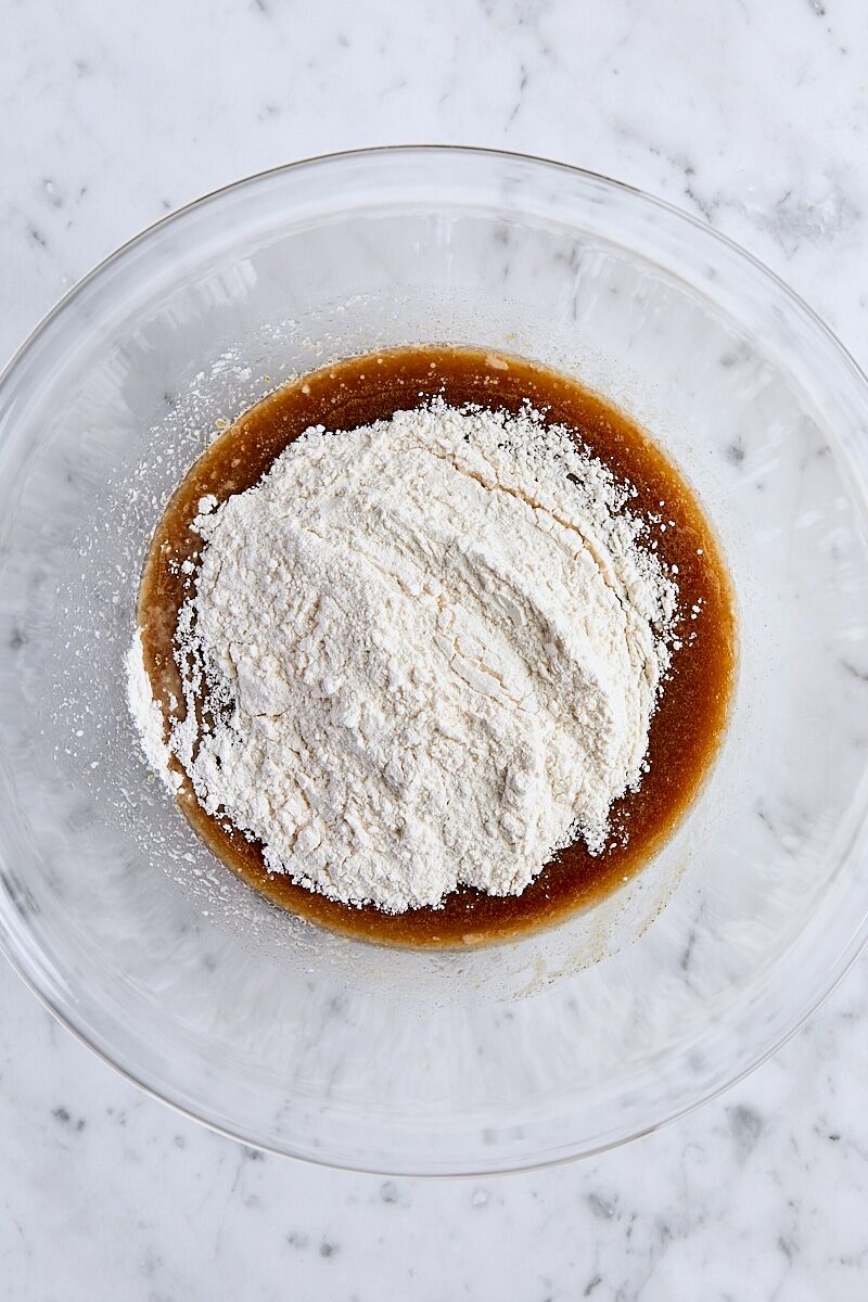Flour added to blondie batter in glass bowl
