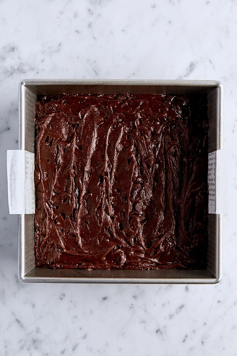 Brownie batter in parchment-lined square pan
