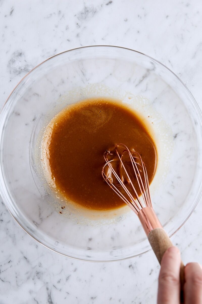 Melted butter, instant espresso powder, vanilla, egg, and egg yolk whisked together in glass bowl