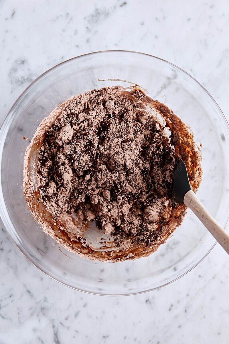 Folding brownie mix into wet ingredients with a spatula