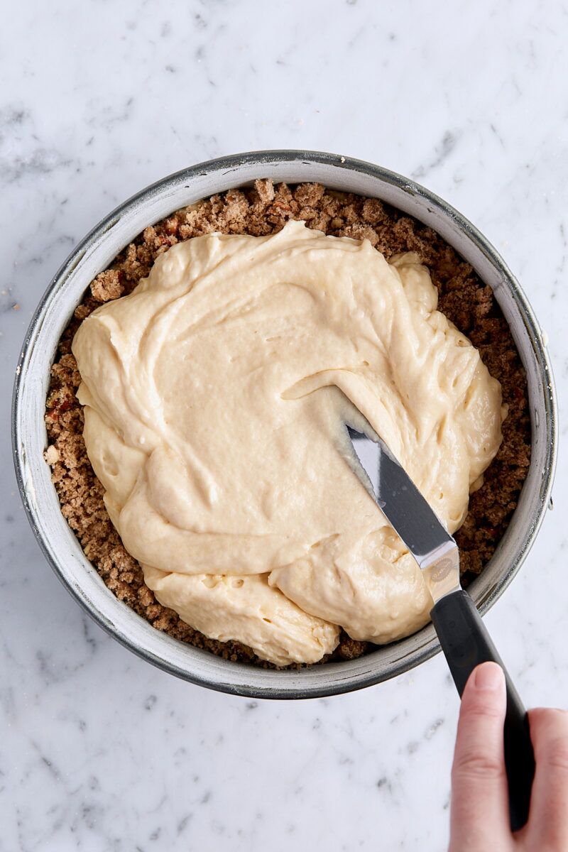 Spreading coffee cake batter over the streusel layer with an offset spatula