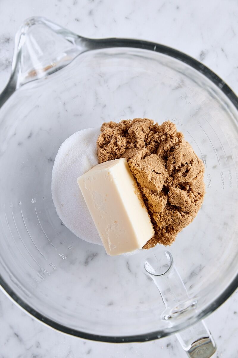 Room temperature butter, brown sugar, and granulated sugar in glass mixing bowl