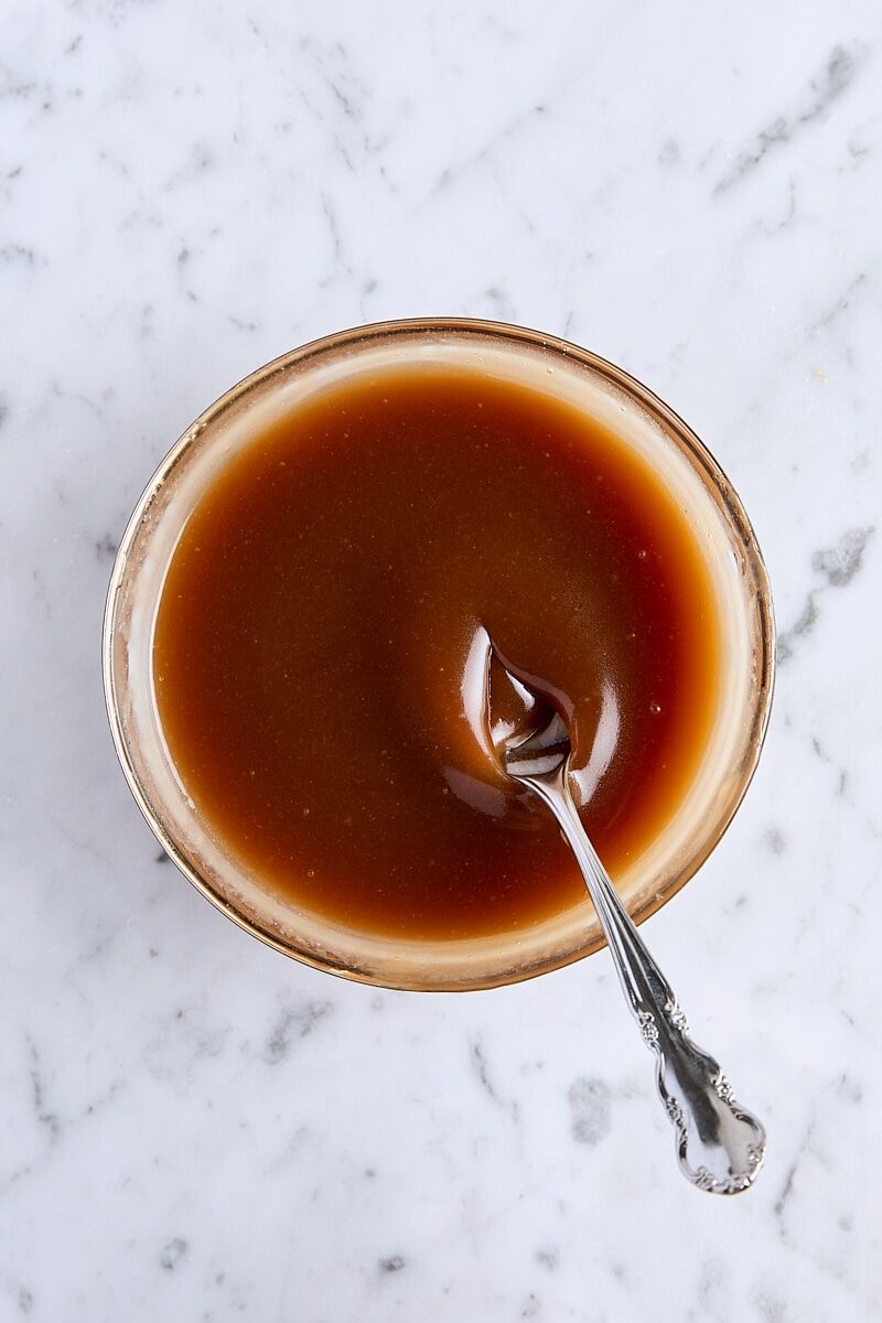 Homemade butterscotch sauce in glass bowl with spoon
