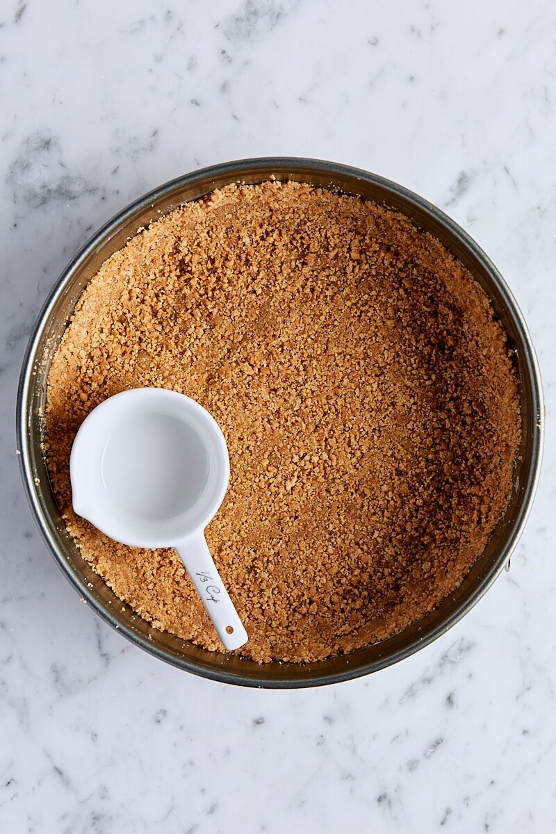 Packed graham cracker crust in springform pan