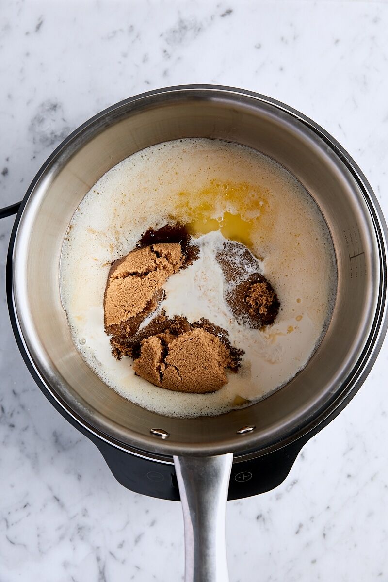 Dark brown sugar, heavy cream, and lemon juice added to saucepan with melted butter