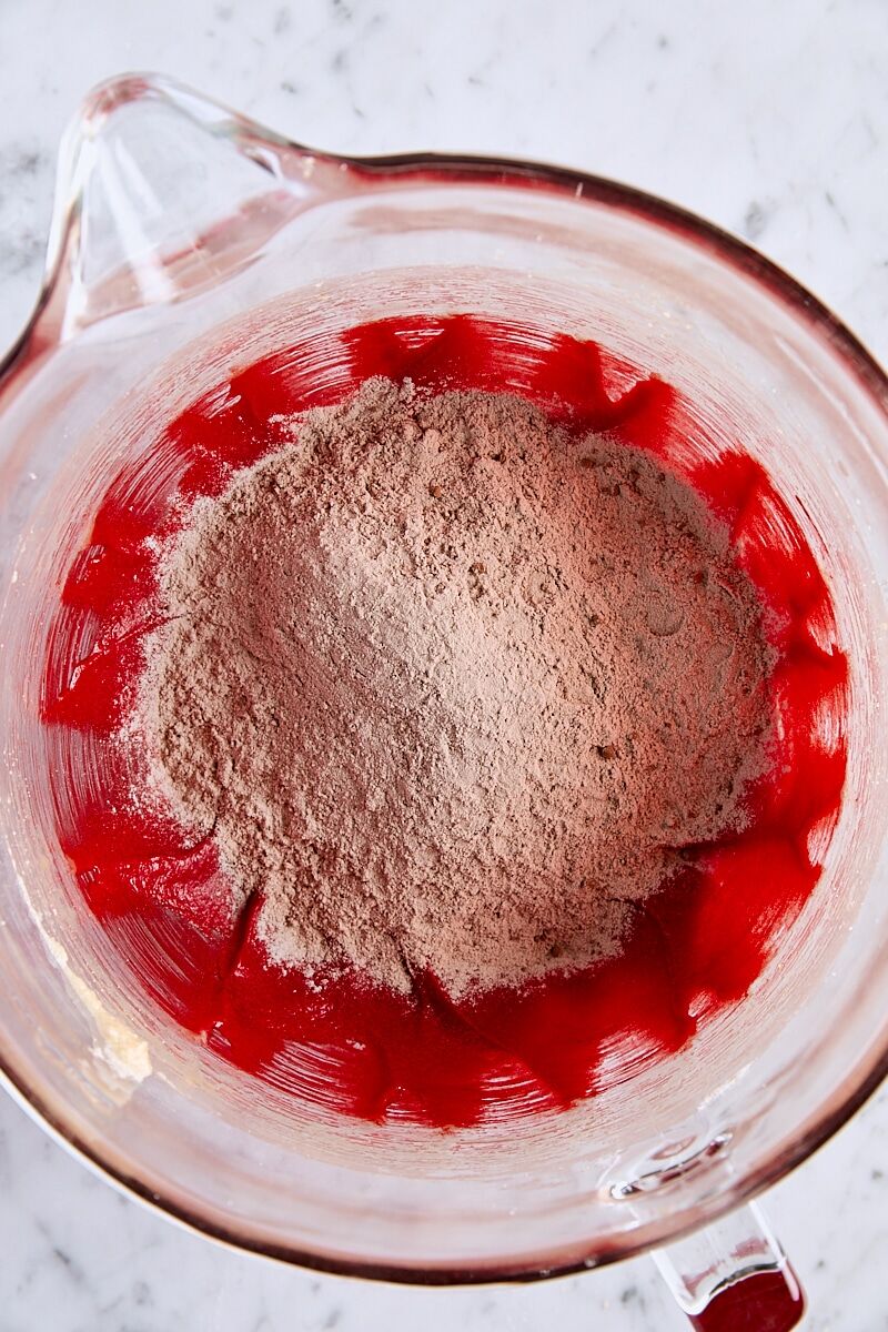 Dry ingredients added to cookie dough in glass mixing bowl