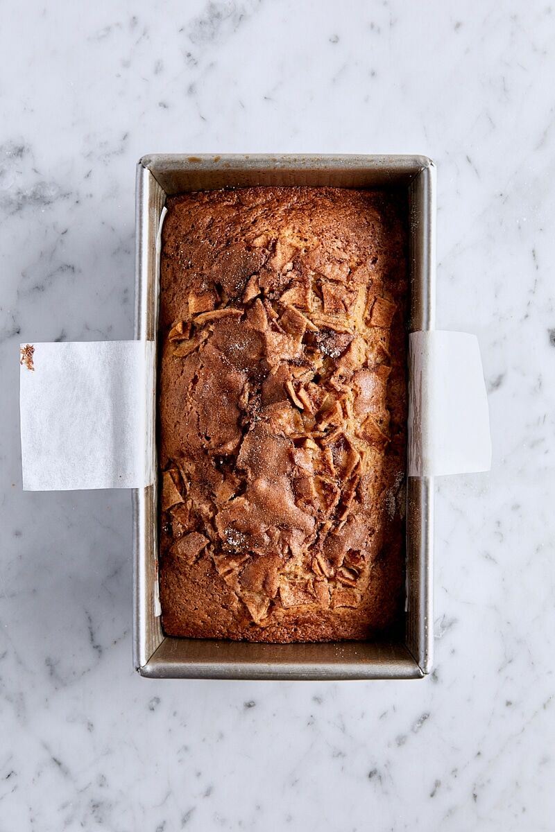 Baked apple fritter bread in parchment-lined loaf pan