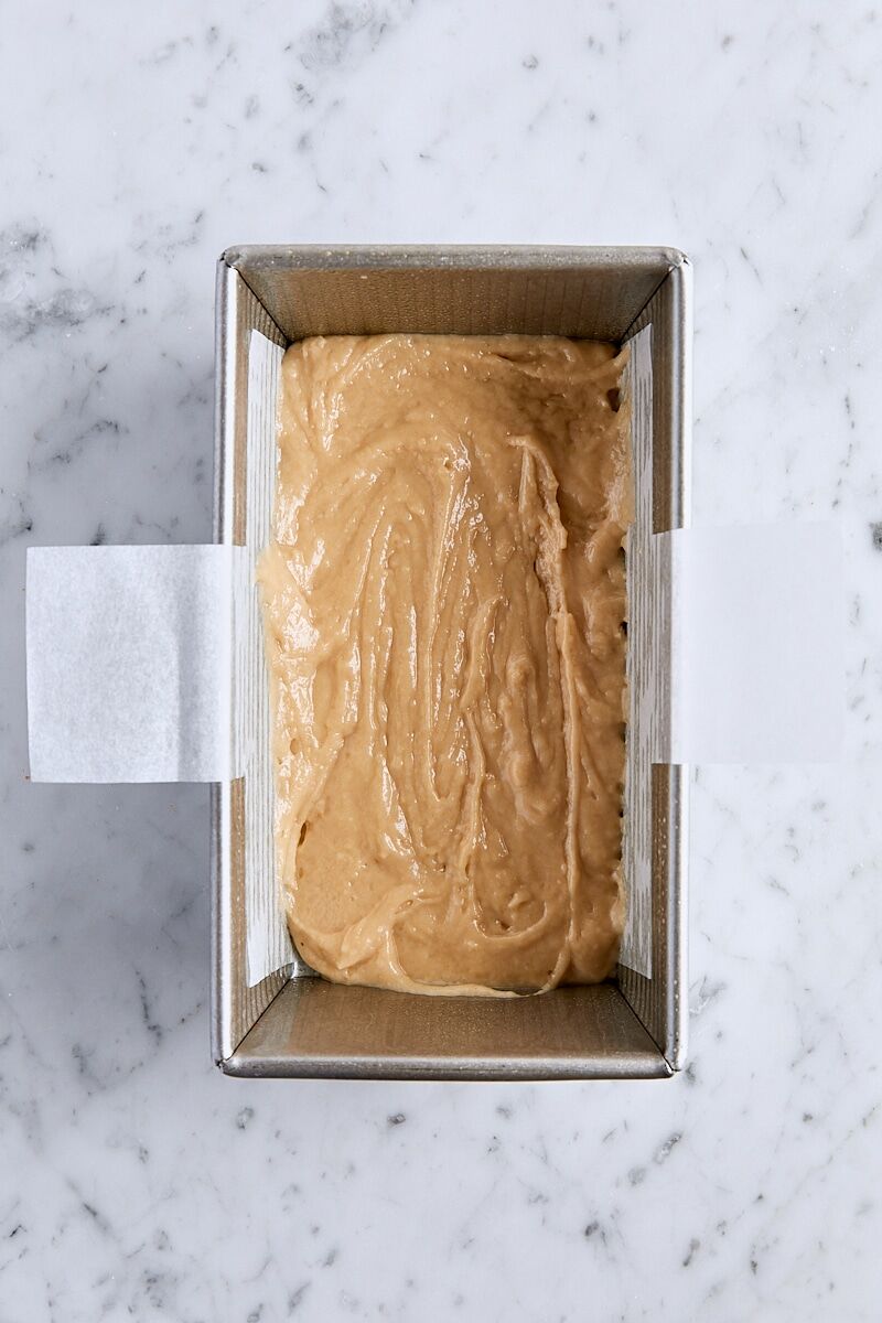 Half of the apple bread batter in parchment-lined loaf pan