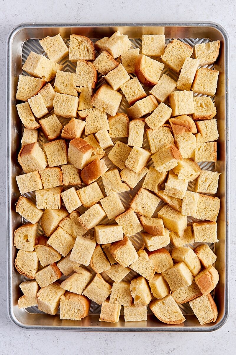 Cubed brioche bread on rimmed baking sheet