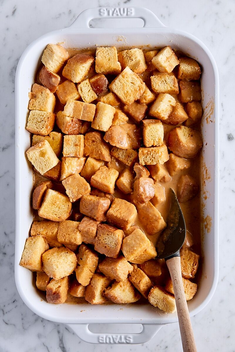 Cubed brioche bread coated with pumpkin custard in baking dish