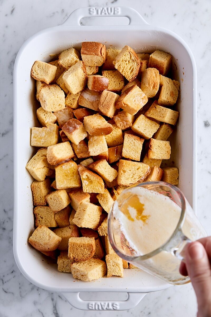 Pour melted butter over brioche cubes in baking dish