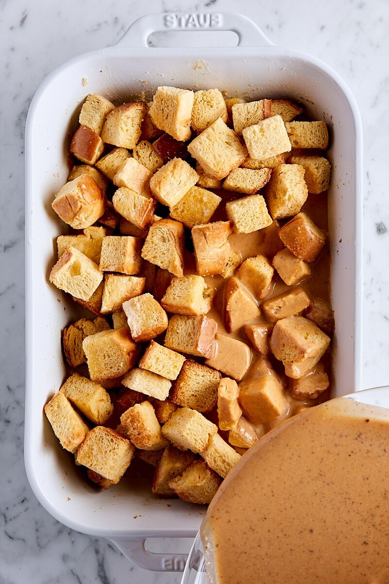 Pour pumpkin custard over brioche bread cubes in baking dish