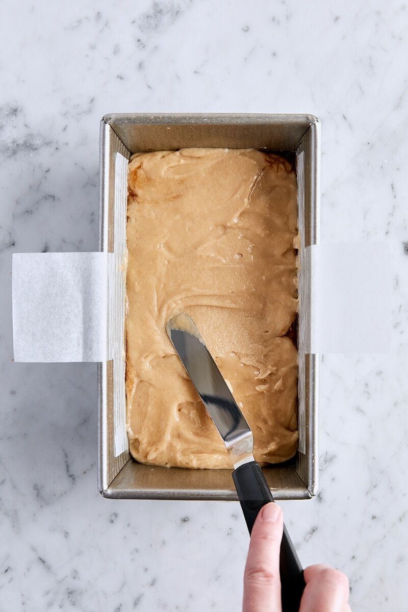 Spreading apple fritter bread batter over the chopped apple layer with an offset spatula
