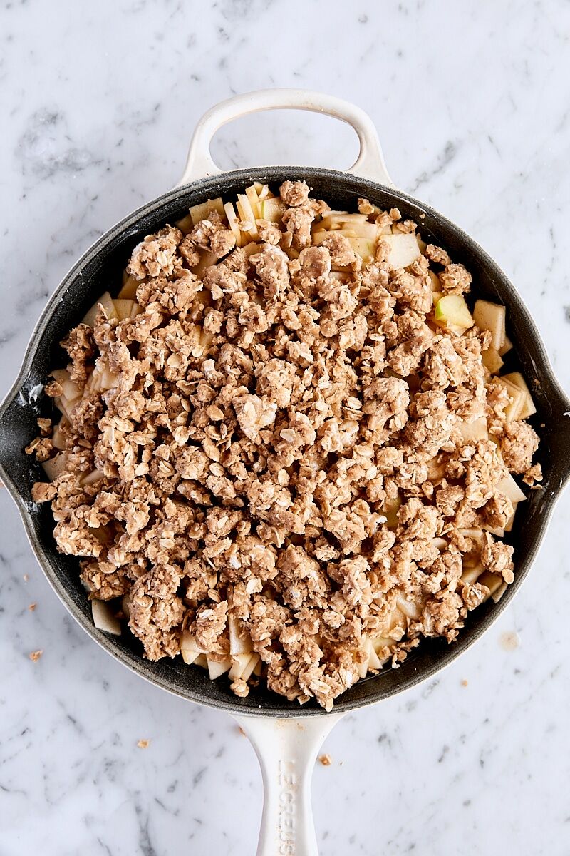 Assembled un-baked apple crisp in cast-iron skillet