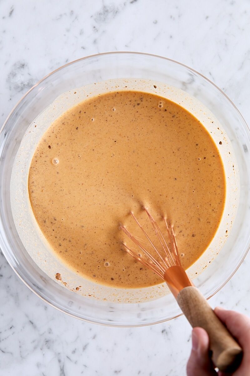 Whisked pumpkin custard in large glass bowl