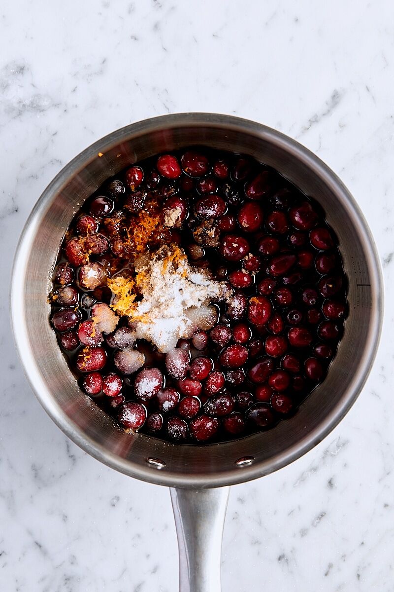 Cranberries, granulated sugar, brown sugar, orange zest, almond extract, and water in saucepan