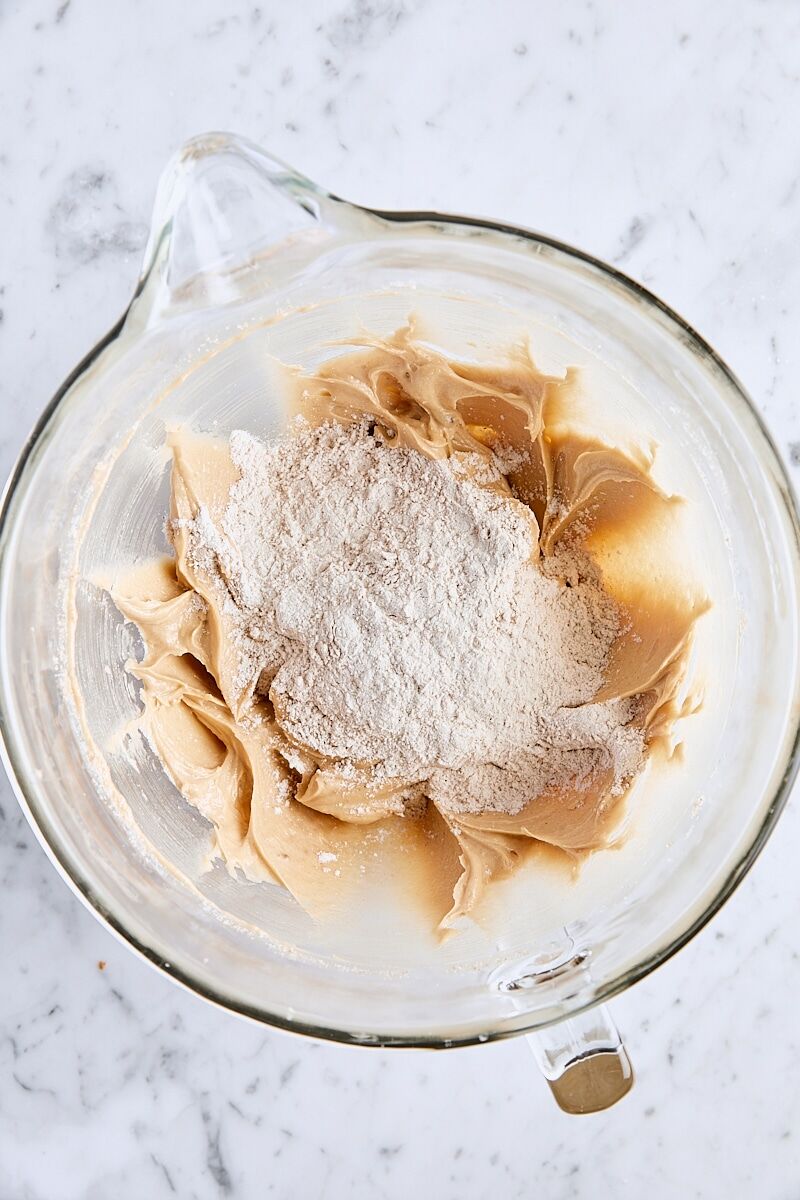Dry ingredients added to bundt cake batter in glass mixing bowl
