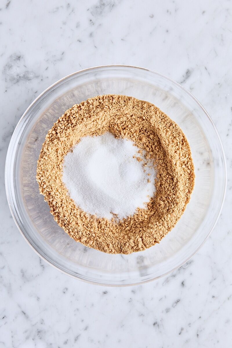 Graham cracker crumbs, granulated sugar, and salt in glass bowl