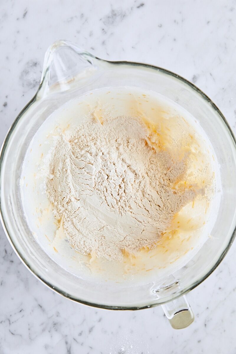 Flour added to shortbread dough in glass mixing bowl