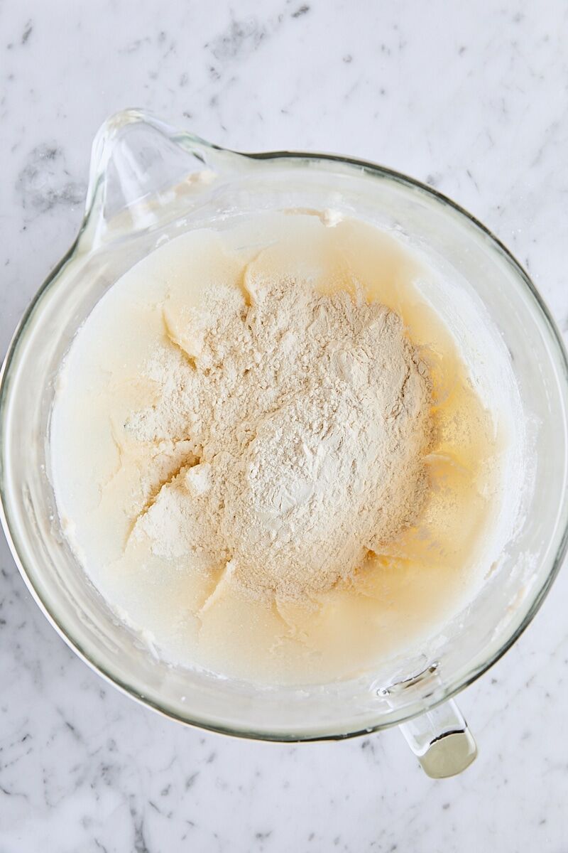 All-purpose flour added to shortbread dough in glass mixing bowl