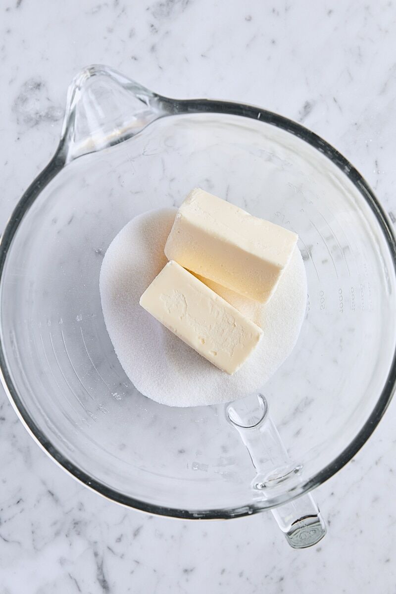 Room temperature butter and granulated sugar in glass mixer bowl