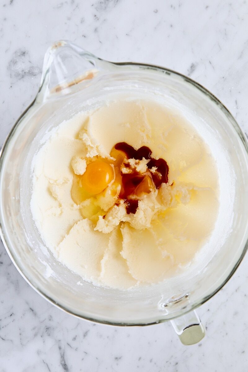 Egg, egg yolk, and vanilla extract added to glass mixer bowl
