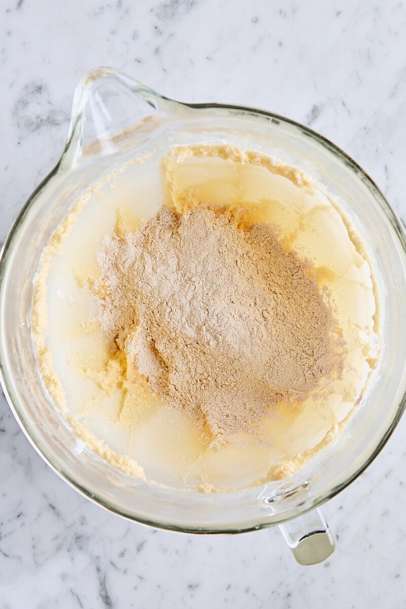 Dry ingredients added to snickerdoodle cookie dough in glass mixing bowl