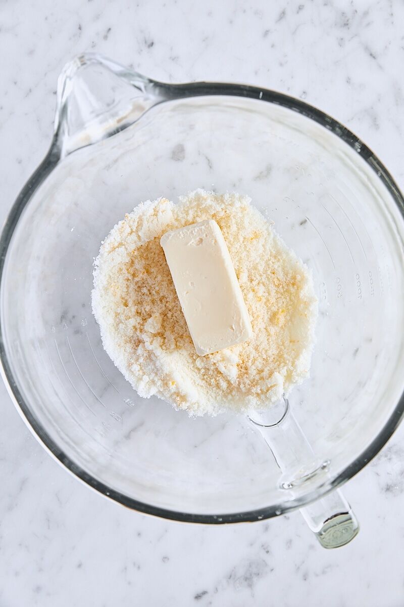 Room temperature butter and lemon-sugar in glass mixer bowl